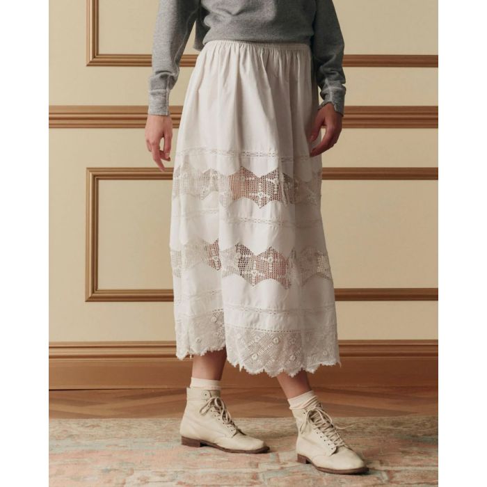 Jupe longue Rosette Crochet The Great en coton et dentelle blanche, portée de profil.