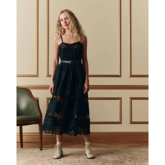 Robe bustier à bretelles Rosette The Great en coton et dentelle noire, portée de face avec une ceinture.