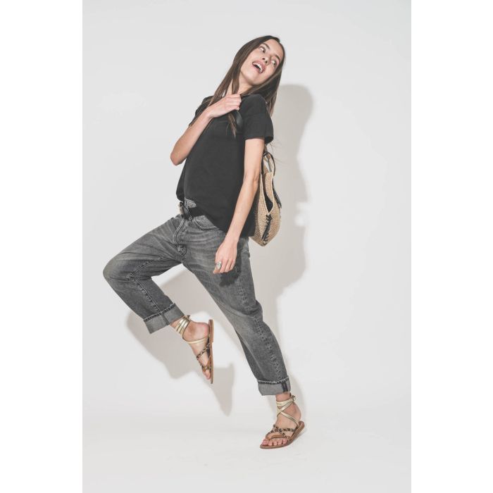 Tee-shirt manches courtes noir Boxy Crew The Great. Porté de profil avec un jean Crossover Leyton Black et des sandales plates Zenobie Pul naturel léopard platine K.Jacques Saint-Tropez. Ceinture en cuir noir Dara Isabel Marant et panier en osier naturel 