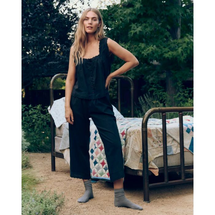 Top à bretelles Eyelet The Great en voile de coton et dentelle noir, porté de face avec un pantalon assorti.