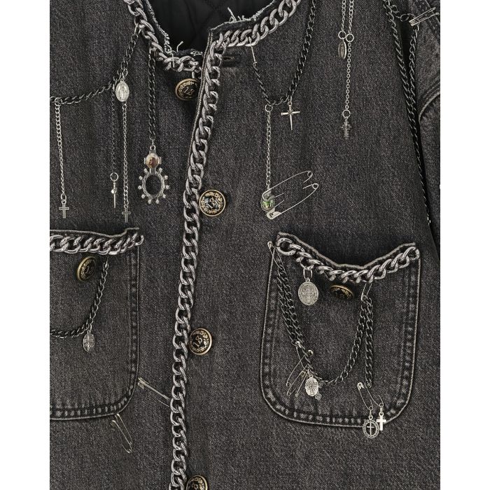 Veste courte Chain Embellished Cropped Chore Jacket R13 en denim gris foncé, customisée avec des chaînes, des épingles à nourrice et des médailles en argent. Détail des bijoux.