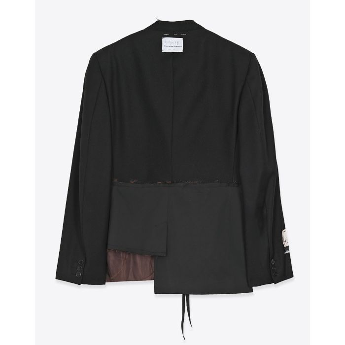 Blazer customisé par Yekaterina Ivankova Upcycling en laine vierge noir. Détail du bas avec un côté plus court que l'autre. Vue de dos.