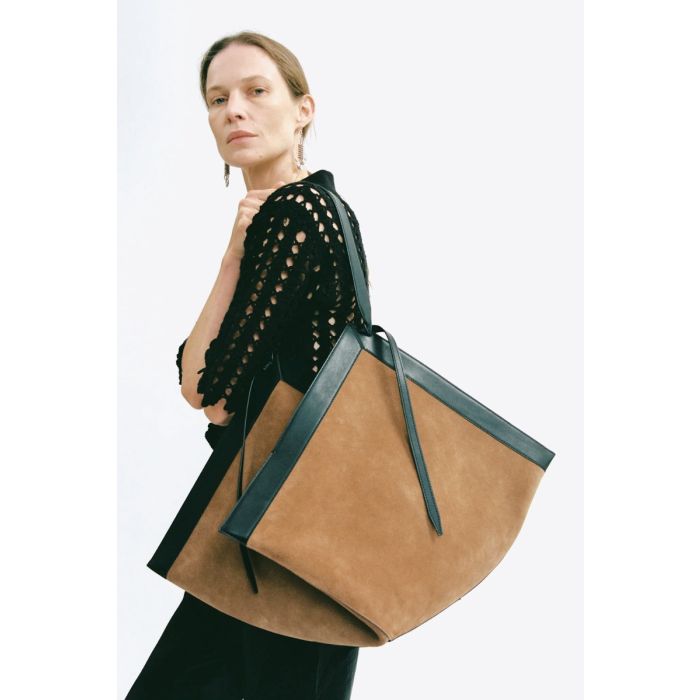 Sac cabas Wonton Yuzefi en cuir suédé cognac, porté de profil à l'épaule.