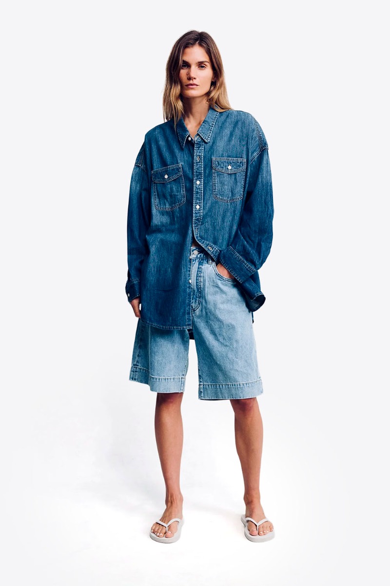 Short long Keaton Relaxed Denimist en denim &laquo; Stone Wash Blue &raquo;, port&eacute; de face avec une chemise en jean bleu fonc&eacute;.