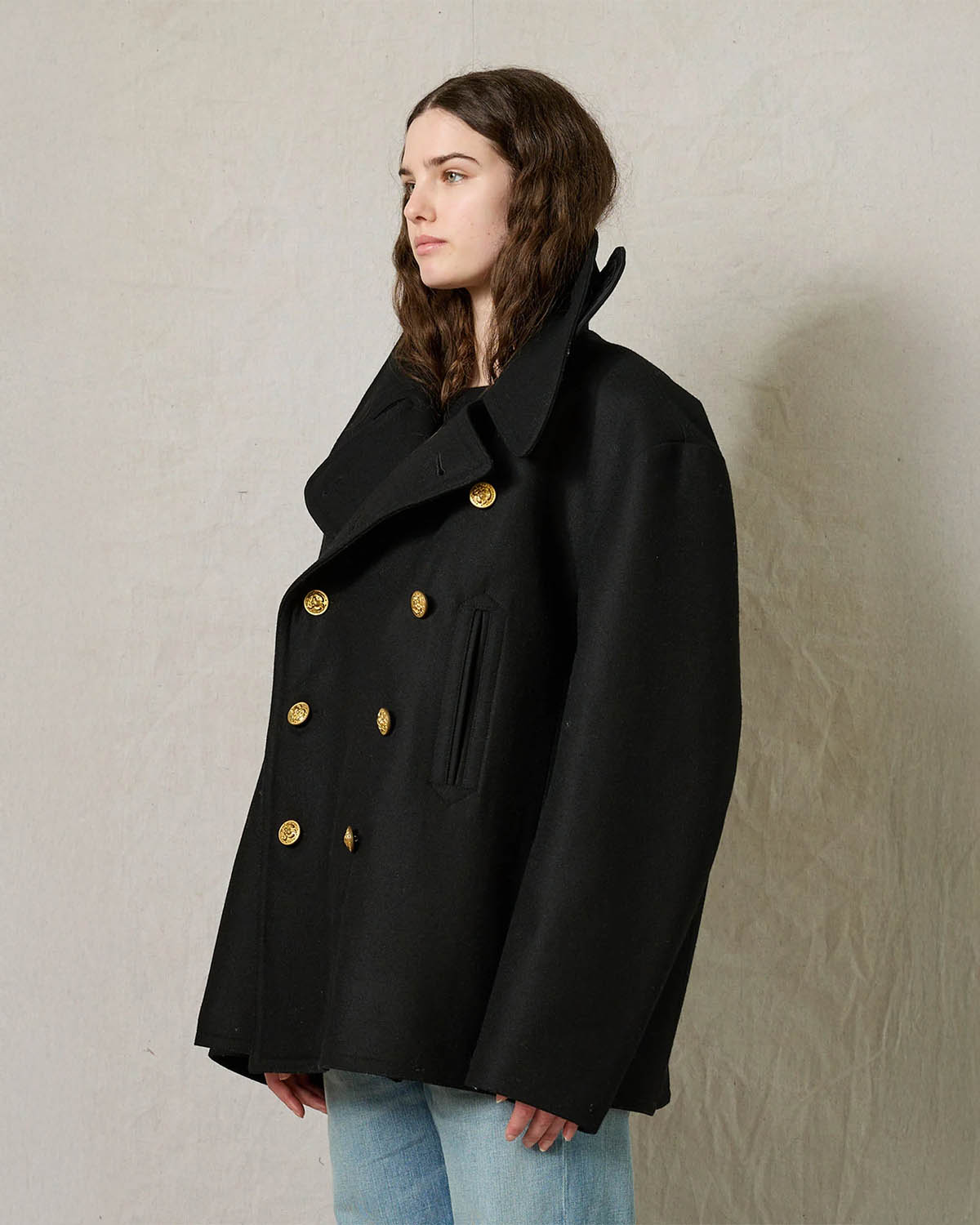 Caban oversize en drap de laine noir boutons gravés dorés Denimist. Porté de profil.