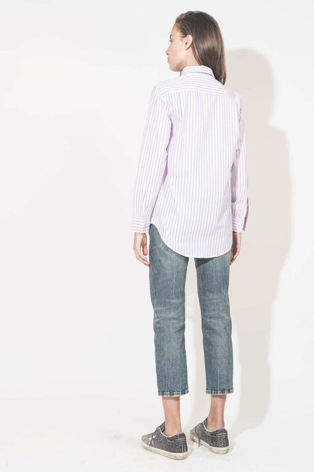 Chemise en popeline de coton rayé rose-bleu-blanc Boyfriend Denimist. Portée de dos avec un jean Boy Straight bleu R13 denim et des sneakers en cuir à paillettes Super-Star Golden Goose. 