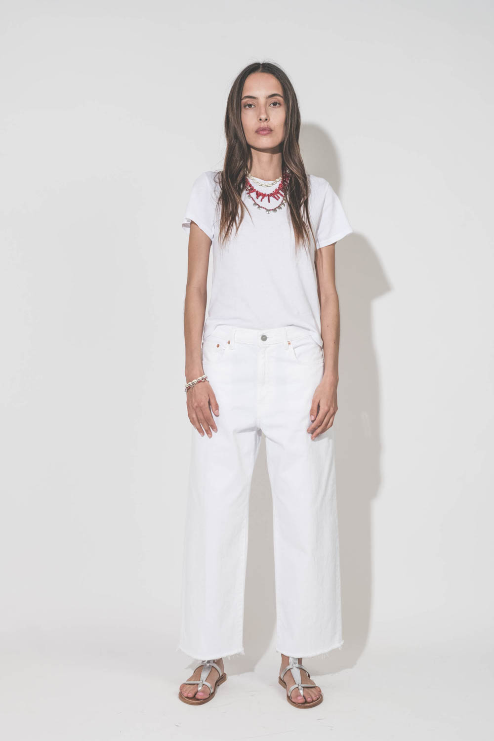 Jean large taille basse en toile blanche lavée Georgia Denimist. Porté avec un tee-shirt Little blanc The Great et des sandales Caravelle en cuir argent K.Jacques Saint-Tropez. Bijoux Isabel Marant.