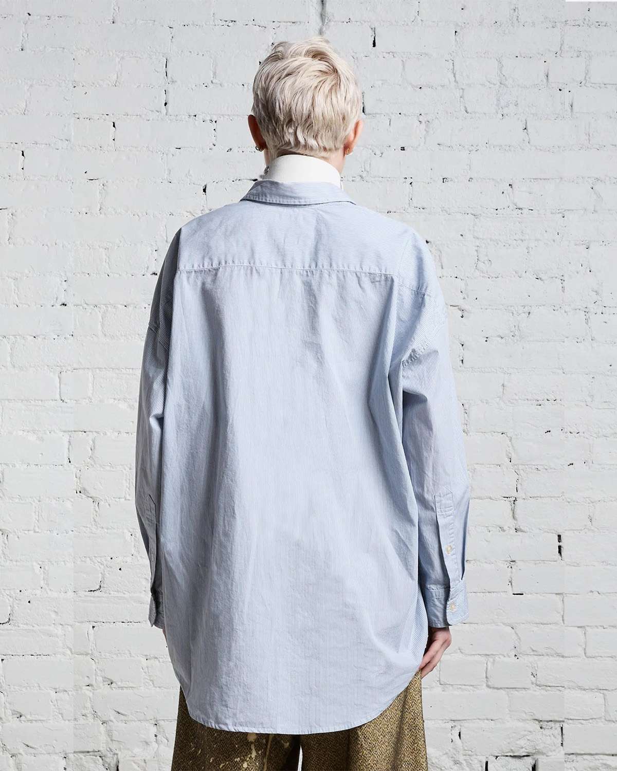 Chemise manches longues oversized rayures bleu ciel et blanches R13. Porté dos.