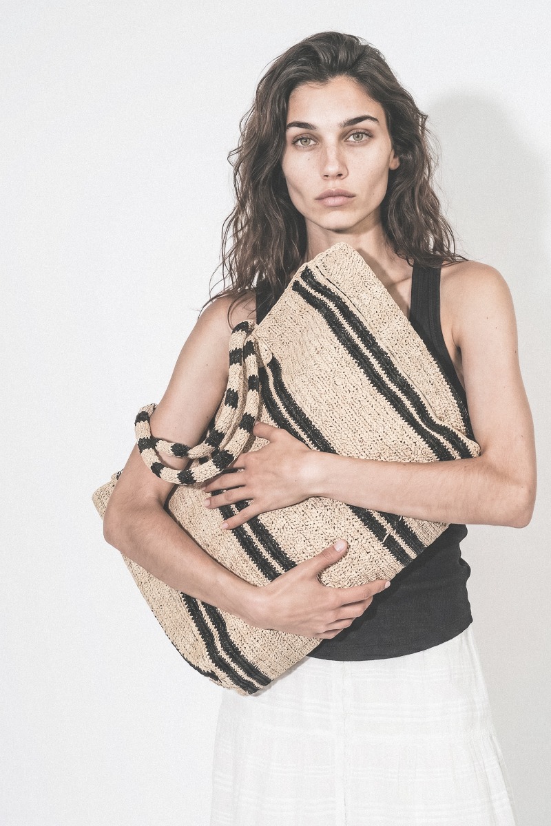 Grand Cabas Raffia Weekender Vacation Road Gabriele Frantzen en raphia rayé écru et noir, porté dans les bras.