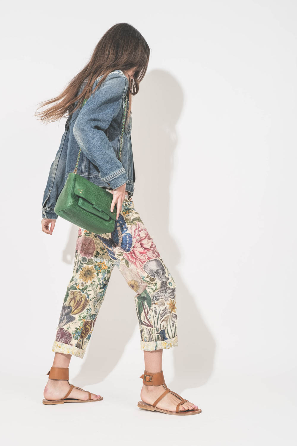 Blouson en jean ajusté en denim bleu Golden Goose. Porté de profil avec un sac en cuir vert.