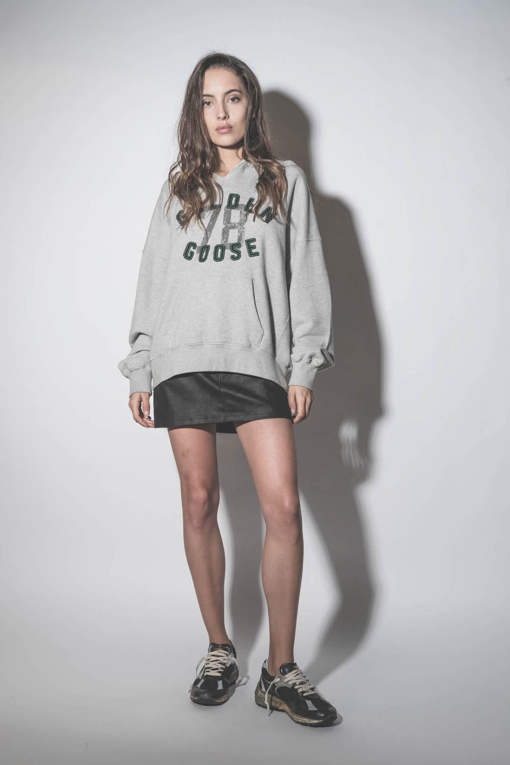 Baskets Running Dad noir et argent 90282 Golden Goose femme. Porté avec un sweatshirt à capuche à logo.