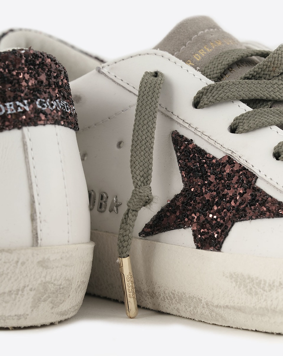 Sneakers Superstar Golden Goose femme en cuir blanc avec &eacute;toile et talon arri&egrave;re &agrave; paillettes marron. D&eacute;tail de l'&eacute;toile &agrave; paillettes marron.