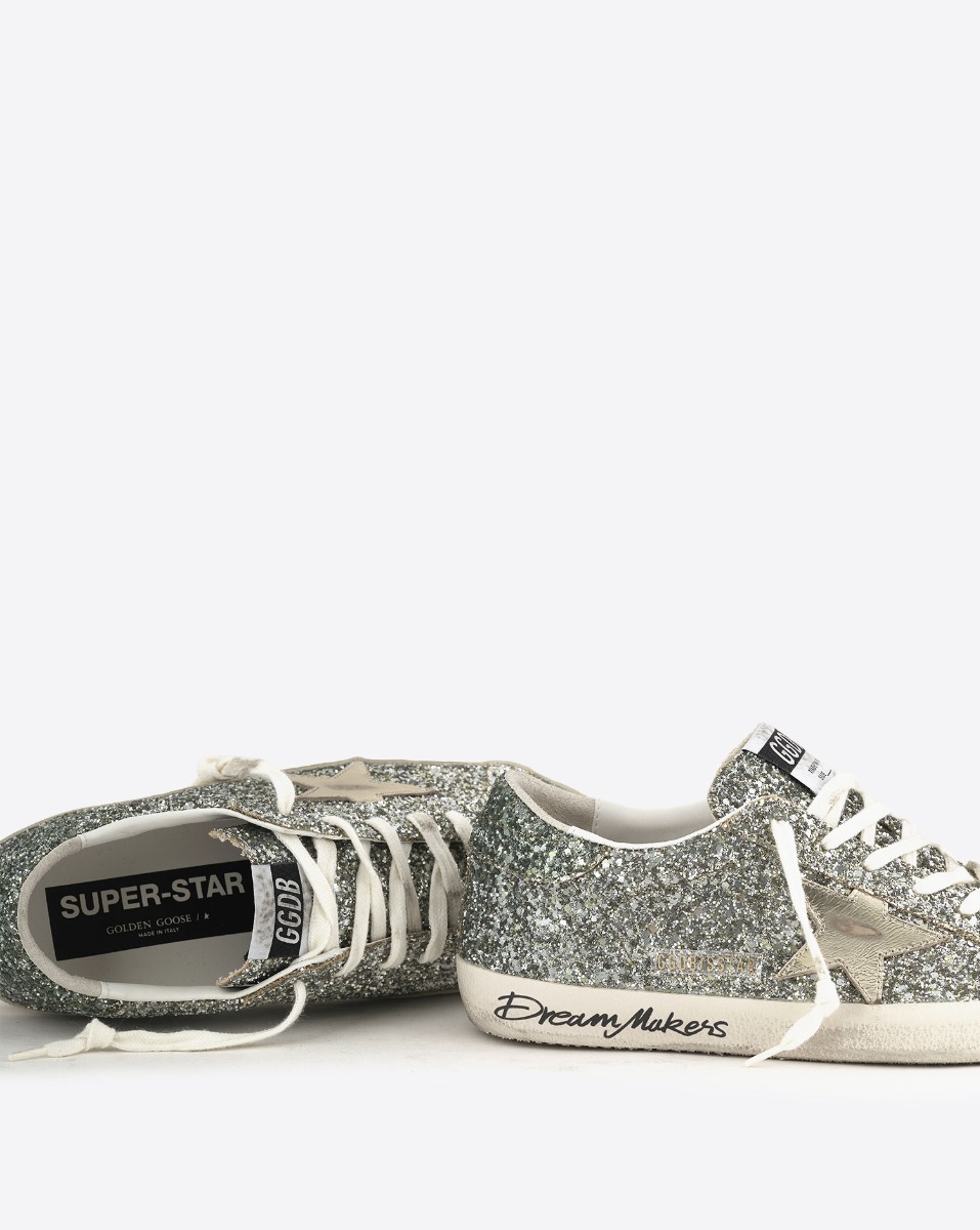 Sneakers Superstar Golden Goose femme &agrave; paillettes argent&eacute;es avec des reflets verts, &eacute;toile en cuir lisse dor&eacute;. D&eacute;tail du graffiti sur la semelle " Dream Makers ". 