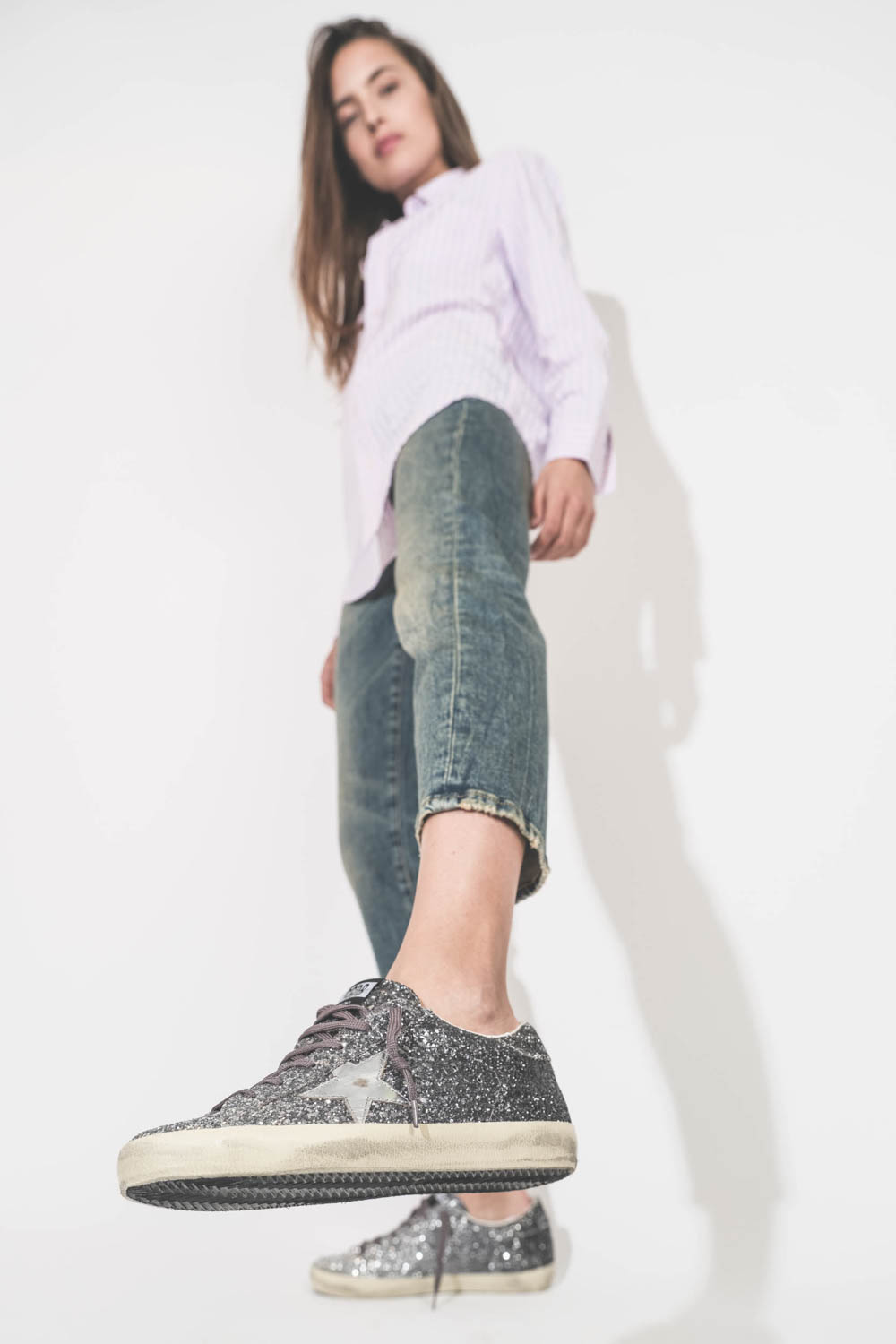 Sneakers entièrement recouvertes de paillettes argentées et noires, étoile en cuir lisse tague écritures noires sur la semelle droite beige "LOVE You To The Star And Back"  Super-star Golden Goose femme. porté avec un jean Boy Straight bleu R13 et une che