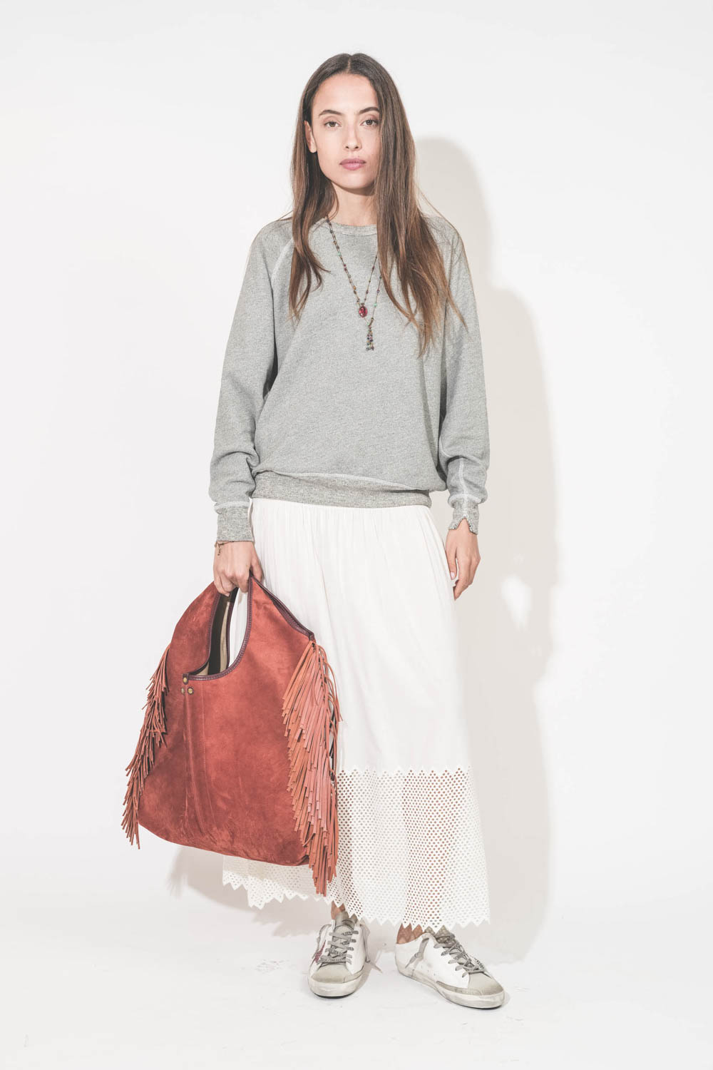 Sneakers Super Star sabot en cuir blanc étoile paillettes rose Golden Goose. porté de face avec un sweat-shirt gris chiné College The Great et une jupe longue en coton blanc nid d'abeille Canary The Great. Sac à franges Paco Terracotta Jérôme Dreyfuss. Sa