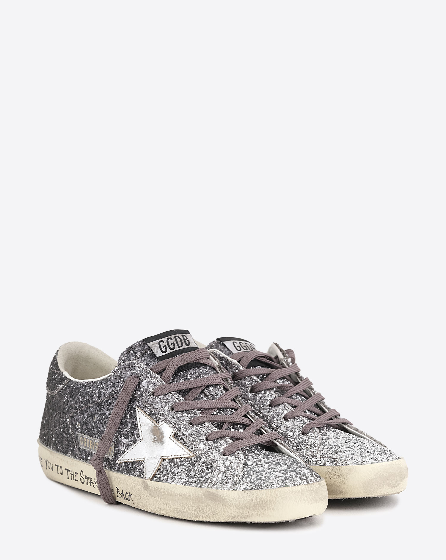 Produit Sneakers entièrement recouvertes de paillettes argentées et noires, étoile en cuir lisse tague écritures noires su la semelle beige "L????VE You To The Star And Back"  Super-star Golden Goose femme. Face.
