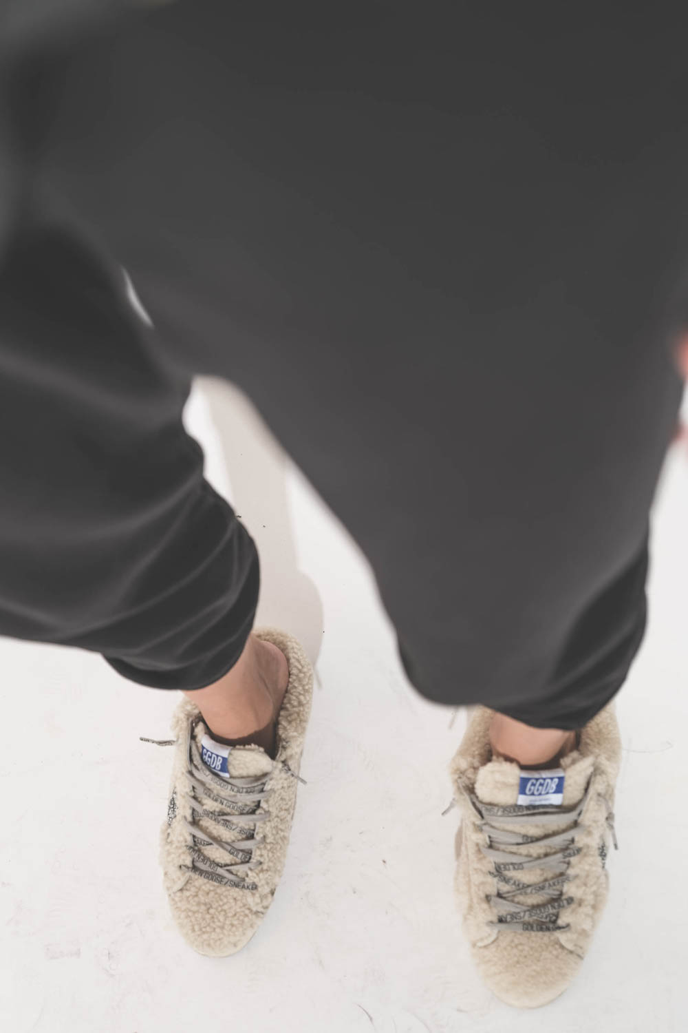 Sneakers sabot en fourrure de mouton retournée écru étoile à paillettes argentées 10757 Super-Star Sabot Golden Goose femme. Portées avec un bas de jogging Cropped noir The Great.