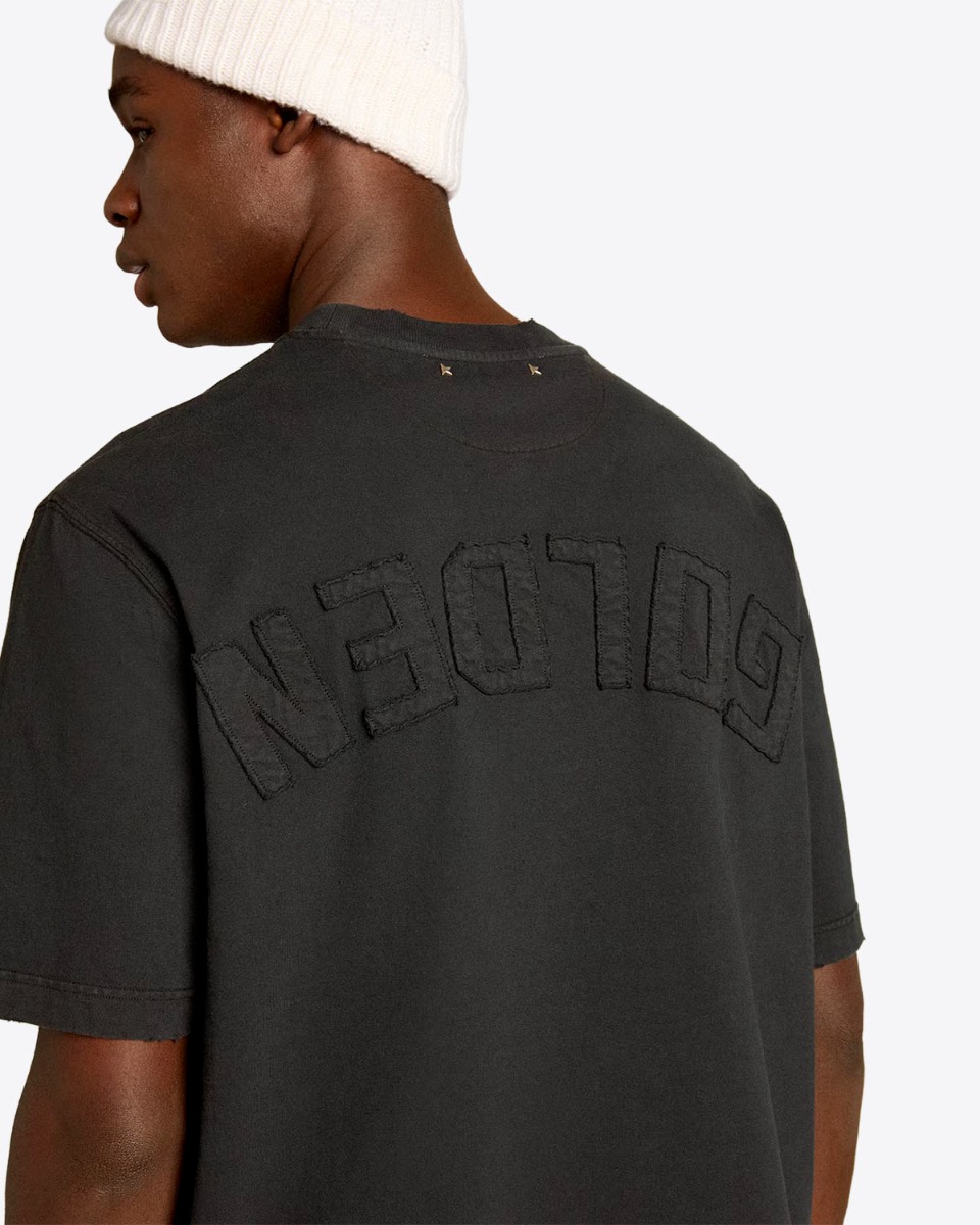 Tee-shirt Relaxed Fit Golden Goose Unisexe en coton noir logo &laquo; GOLDEN &raquo; invers&eacute; dans le dos, port&eacute; de dos.