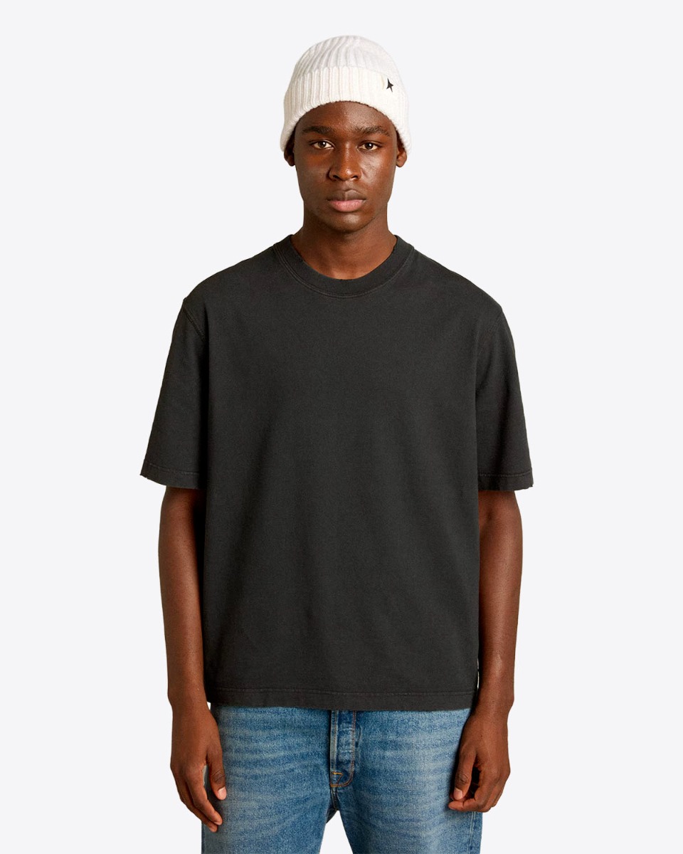 Tee-shirt Relaxed Fit Golden Goose Unisexe en coton noir logo &laquo; GOLDEN &raquo; invers&eacute; dans le dos, port&eacute; de face.