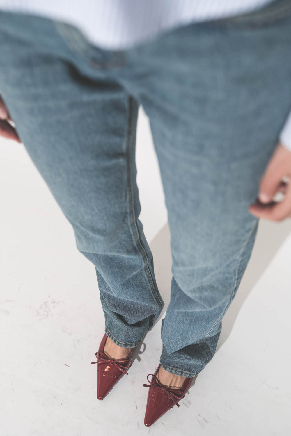 Jean droit taille basse et long bleu délavé 100% coton Carly Haikure. Porté avec une chemise courte à rayures bleues Button Front Denimist et des ballerines rouge Zoey Anine Bing. 