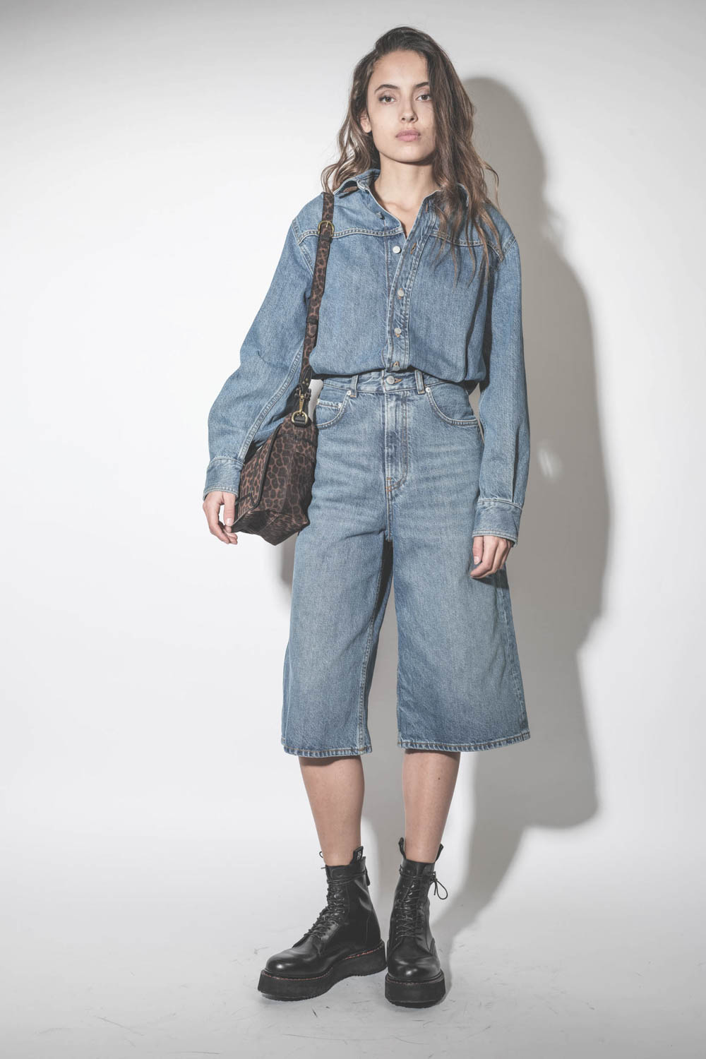 Robe combinaison sous le genoux en jean bleu délavé Méditerranée Tonya Haikure. Porté de face.