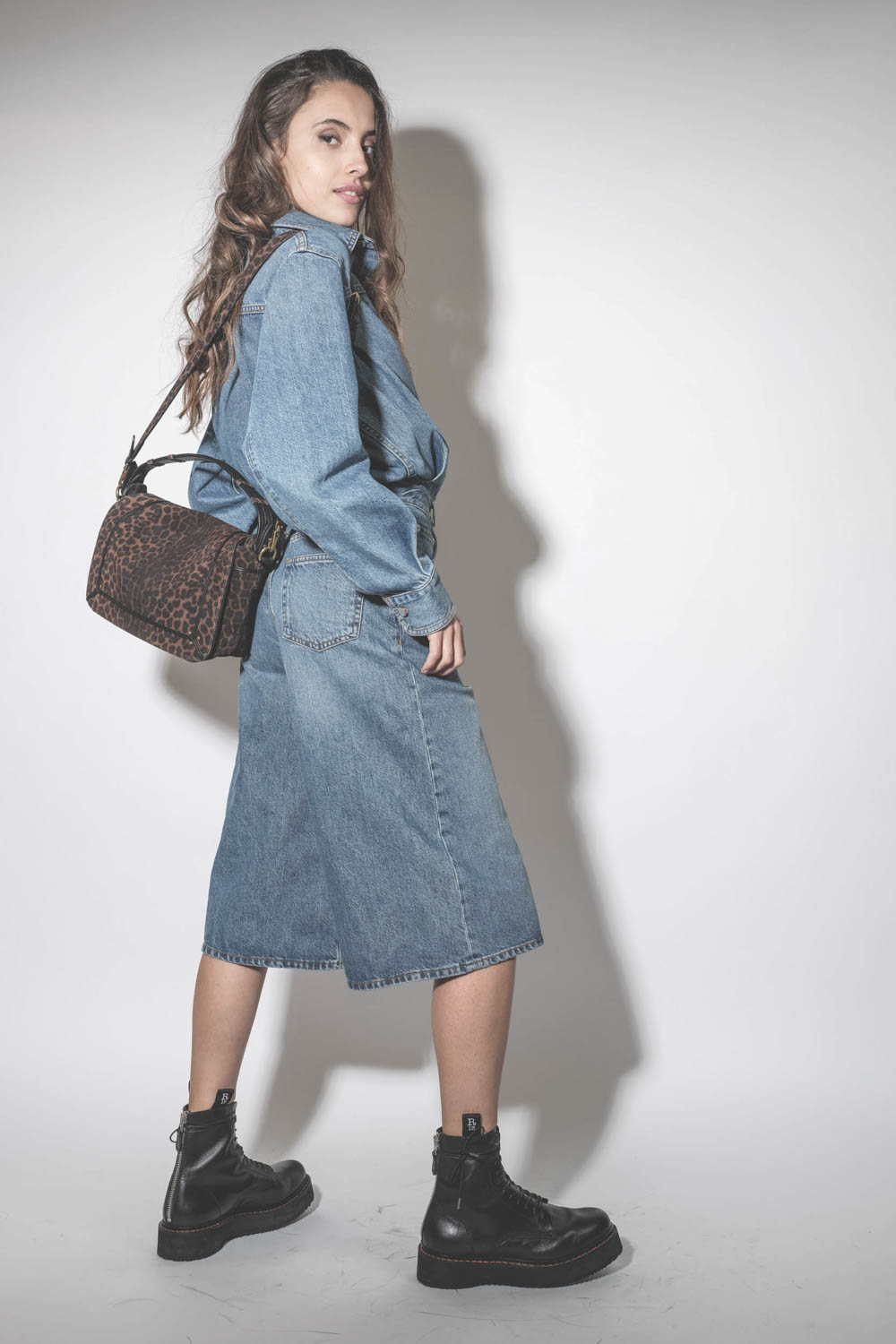 Robe combinaison sous le genoux en jean bleu délavé Méditerranée Tonya Haikure. Porté de profil.