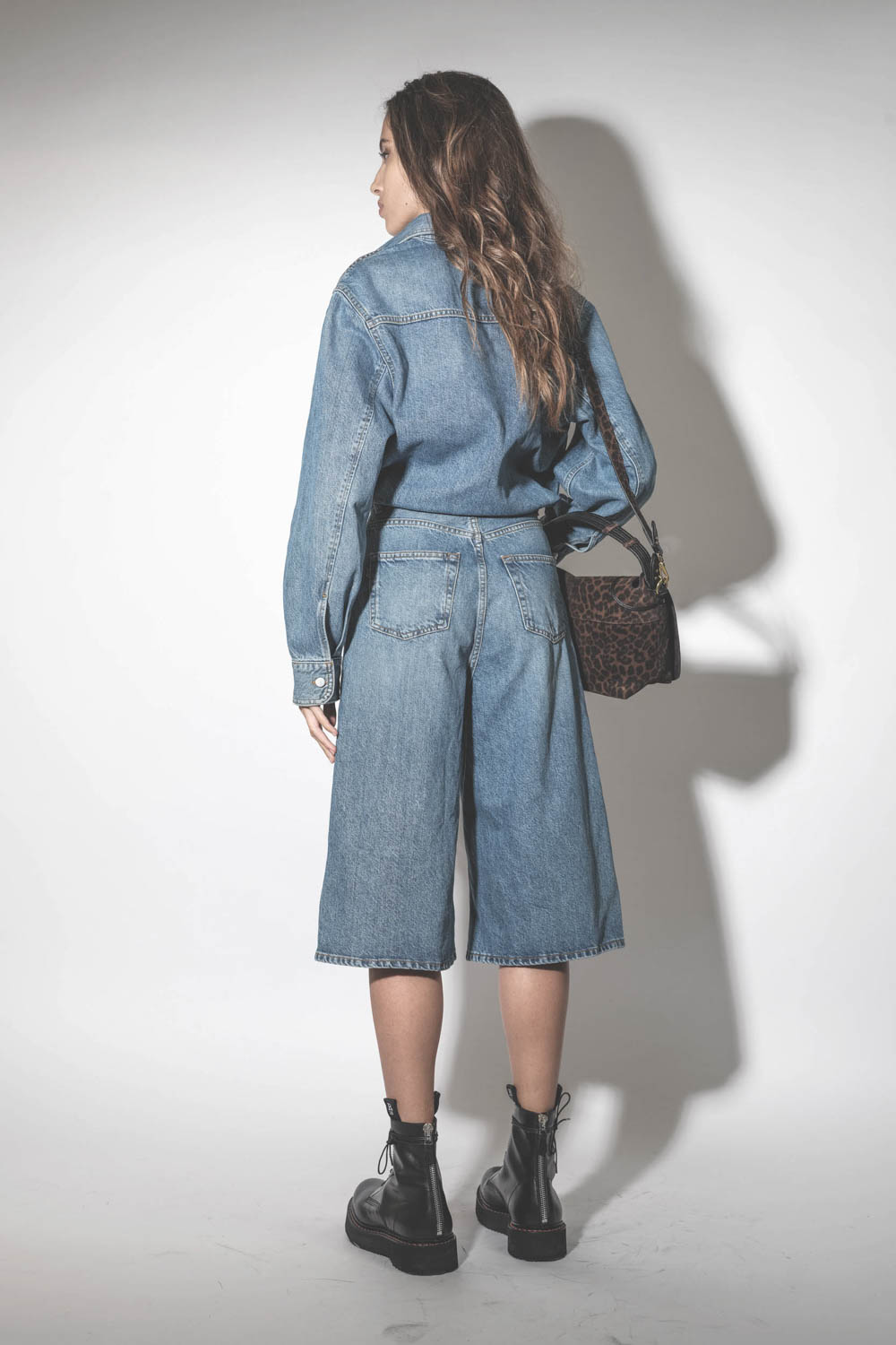 Robe combinaison sous le genoux en jean bleu délavé Méditerranée Tonya Haikure. Porté de dos. 
