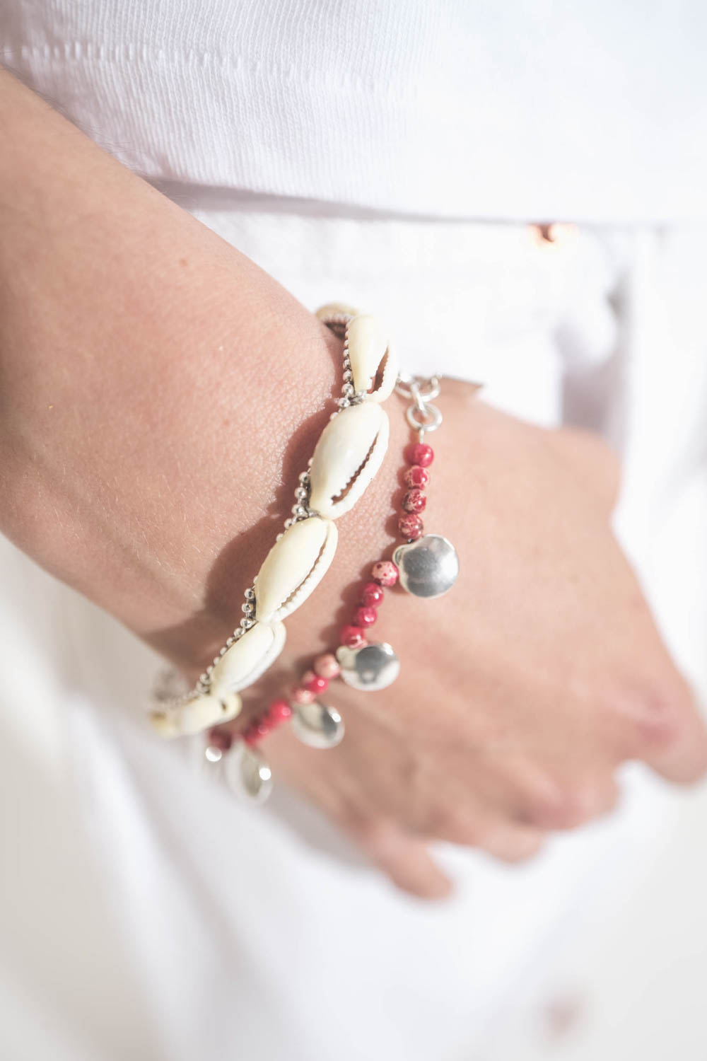Bracelet pierre rouge et pastilles en métal argenté Adriel Isabel Marant. Porté en accumulation avec un bracelet coquillage Noki Isabel Marant.