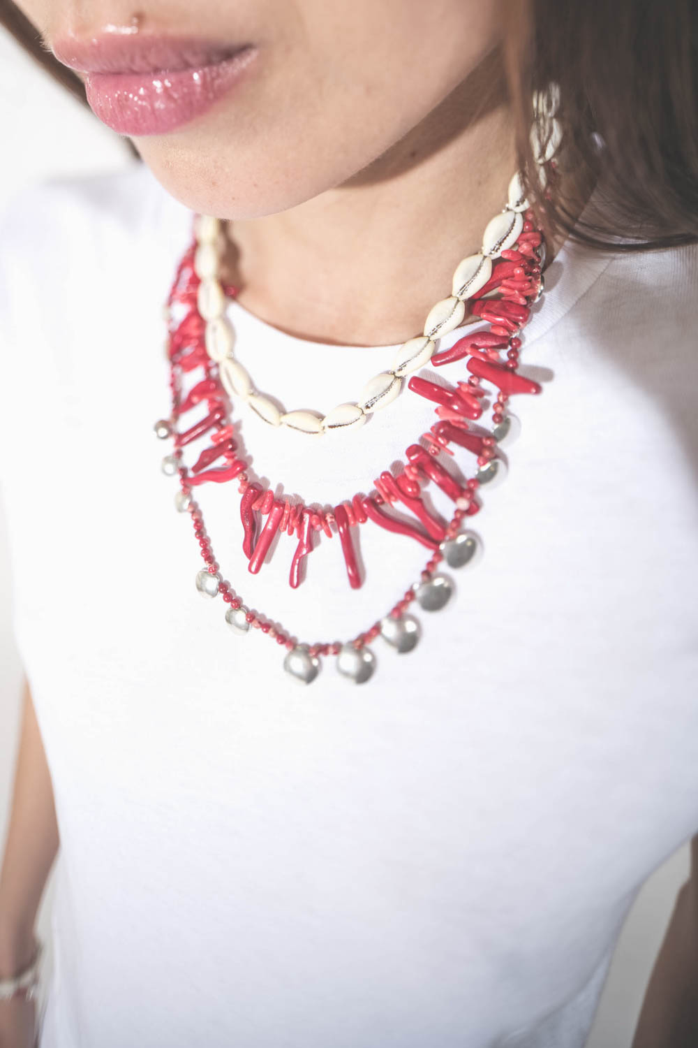 Collier pierres rouges et pampilles en métal argentés Isabel Marant. Porté en accumulation avec un collier coquillage Noki et un collier perles et os rouge Isabel Marant.