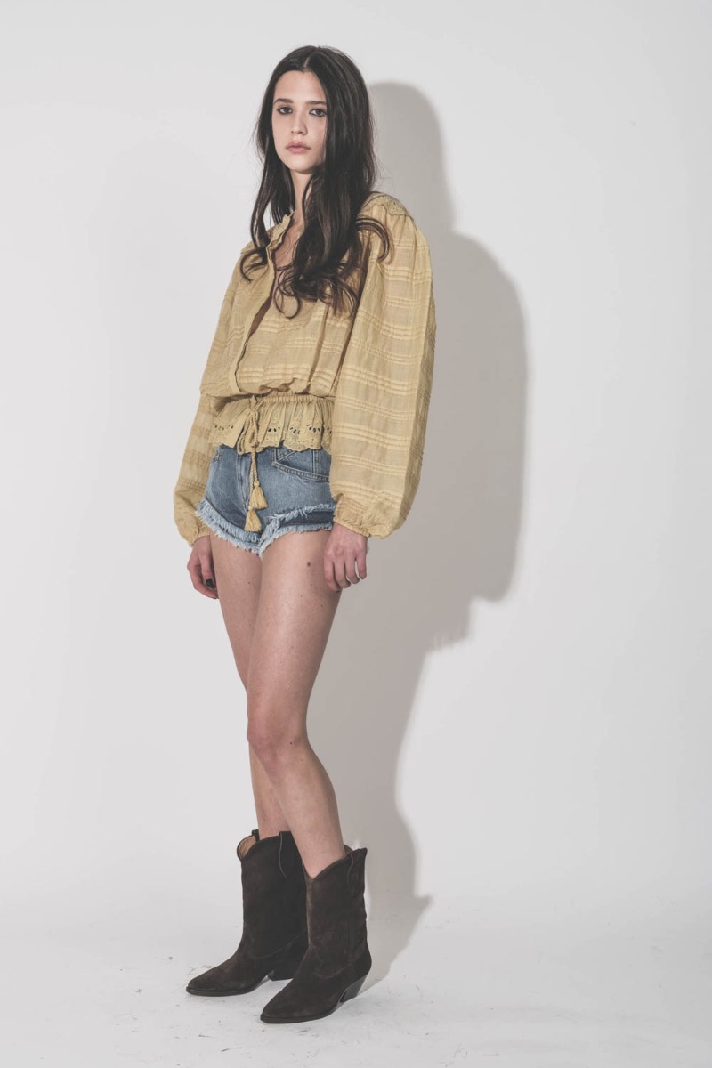 Chemise Polly Isabel Marant &Eacute;toile en voile de coton et en dentelle fleurie ocre, port&eacute;e de profil avec un short en jean Marant &Eacute;toile.