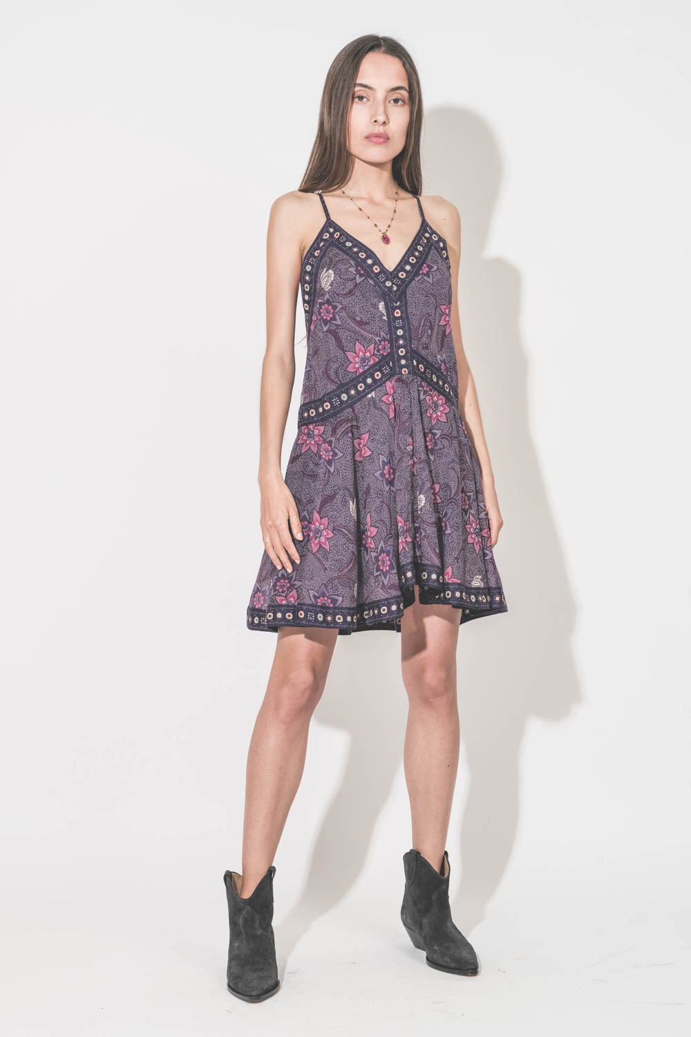 Robe au dessus du genoux fines bretelles en voile de coton imprimé fleurs violettes doublée Daniella Isabel Marant Etoile. Portée avec des boots en cuir suédé noir délavé Dewina Isabel Marant et un collier tibétain Sharing. 