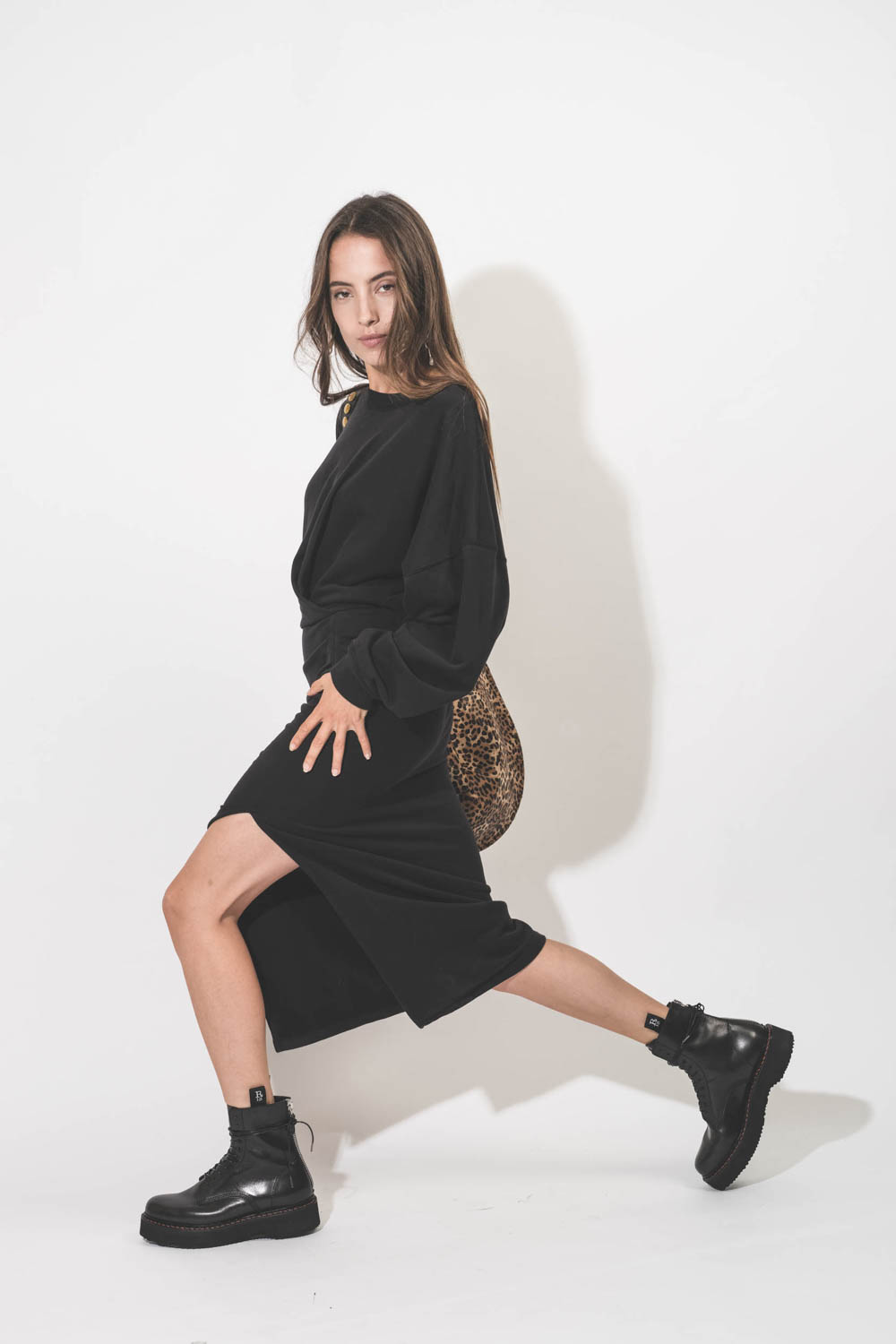 Robe longue manches longues drapée et fendue sur la jambe en sweat-shirt noir Salomon Isabel Marant Etoile. Détail de la fente sur le jambe.