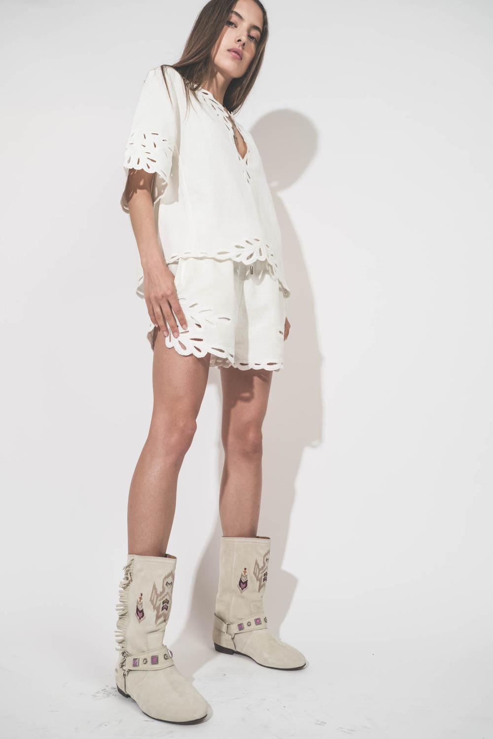 Short court en coton texturé et dentelle Safa Isabel Marant Etoile. Porté avec un top assorti Shana blanc Isabel Marant Etoile et des bottes en cuir suédé et brodé écru Siani Isabel Marant. Collier croix De Jaegher et bague en cristal Alba Pascale Monvois