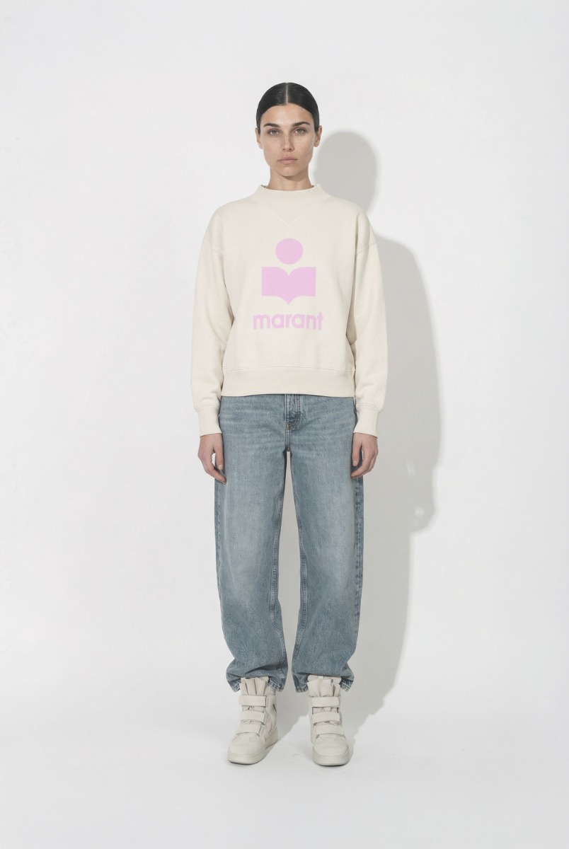 Sweatshirt Moby Isabel Marant &eacute;toile en coton &eacute;cru et logo rose sur le devant, port&eacute; de face avec un jean bleu Fritz Anine Bing. 