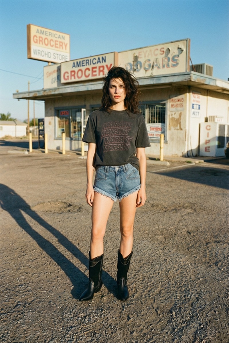 T-shirt Zoeline Isabel Marant &Eacute;toile en coton noir d&eacute;lav&eacute;, logo Marant sur le devant, port&eacute; avec un short en jean bleu ciel et des santiags Isabel Marant.
