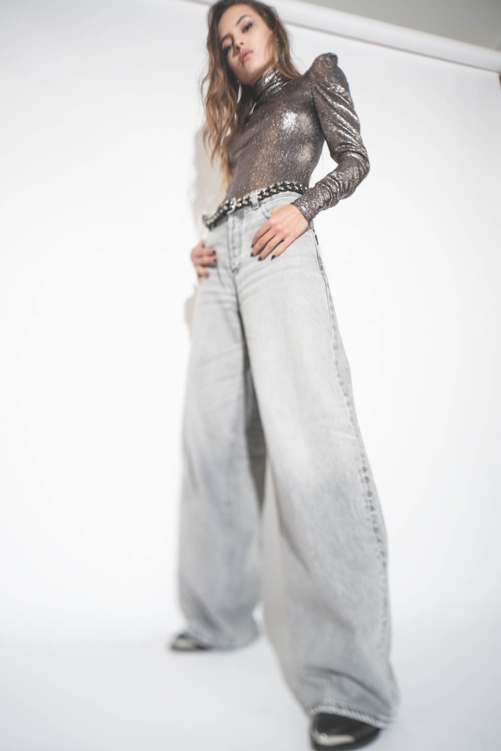 Produit Top près du corps col montant en jersey lamé noir Baiola Isabel Marant Etoile. Porté avec un jean large gris.