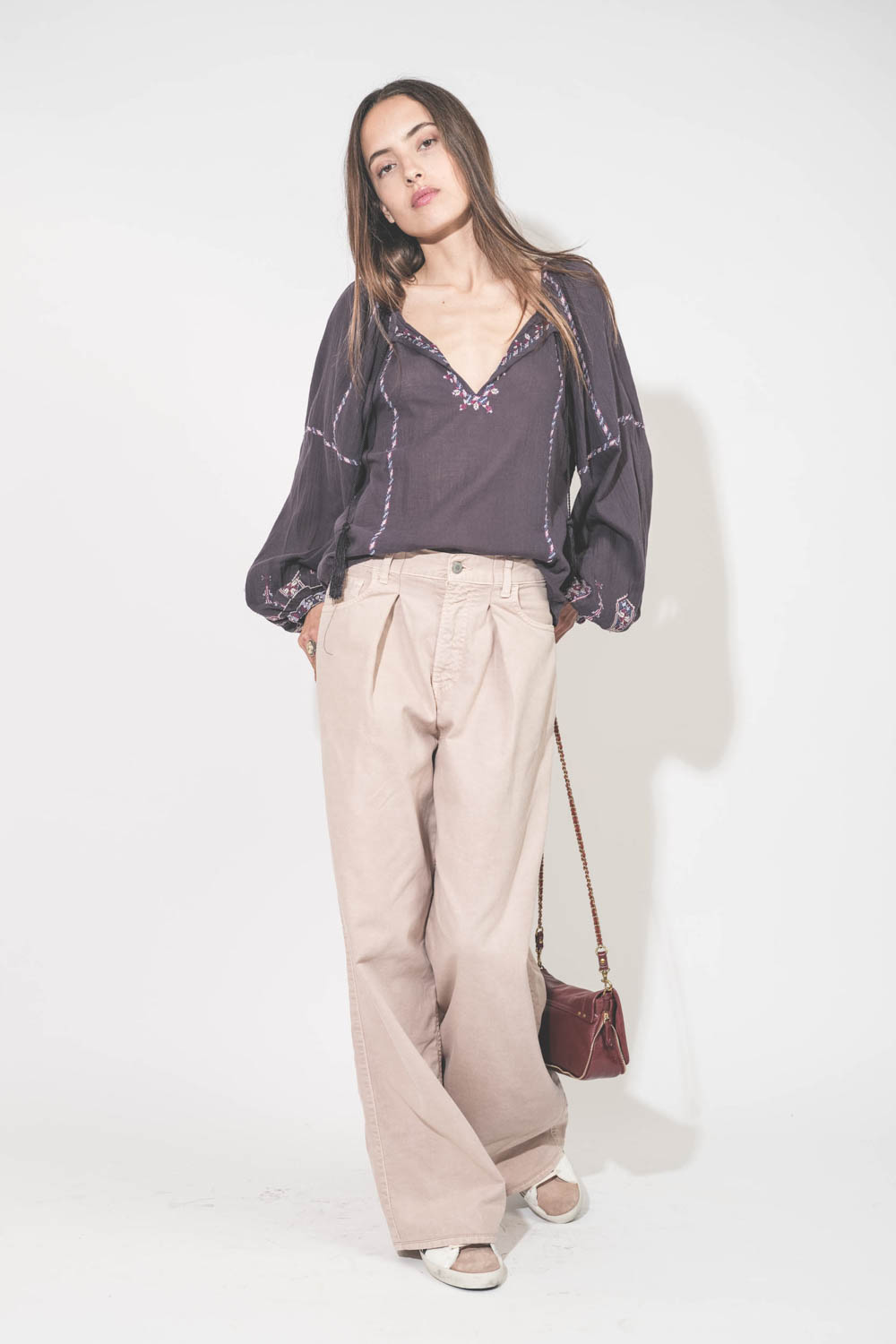 Top manches longues en voile de coton brodé bleu nuit lilas Fernanda Isabel Marant Etoile. Porté de face avec un jean large à pinces en coton rose poudré Candy Twill 45 Haikure. Sneakers en cuir blanc languette rose Super Star 12170 Golden Goose et sac Bo