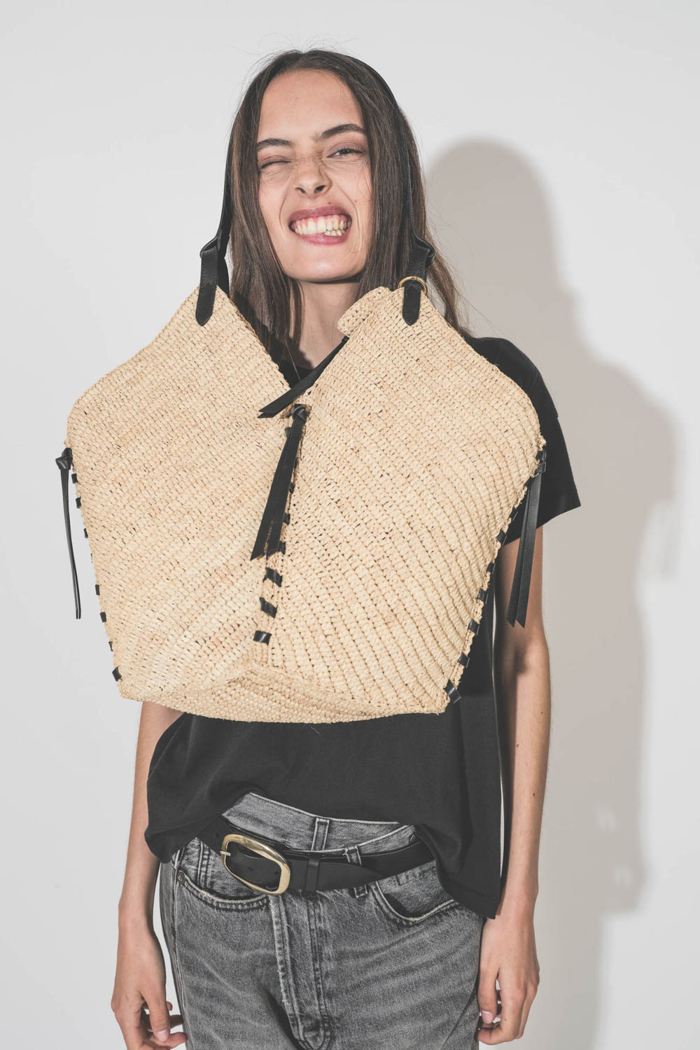 Panier en osier naturel finition cuir noir porté avec humour main ou épaule grand modèle Tampa Isabel Marant. Porté avec un tee-shirt noir Boxy Crew The Great et un jean Crossover Leyton Black R13 Denim. Ceinture Dara Isabel Marant.