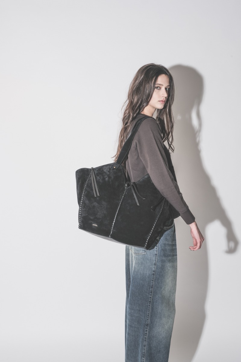 Sac Cabas Tampa Isabel Marant en cuir suédé noir, porté de profil à l'épaule.
