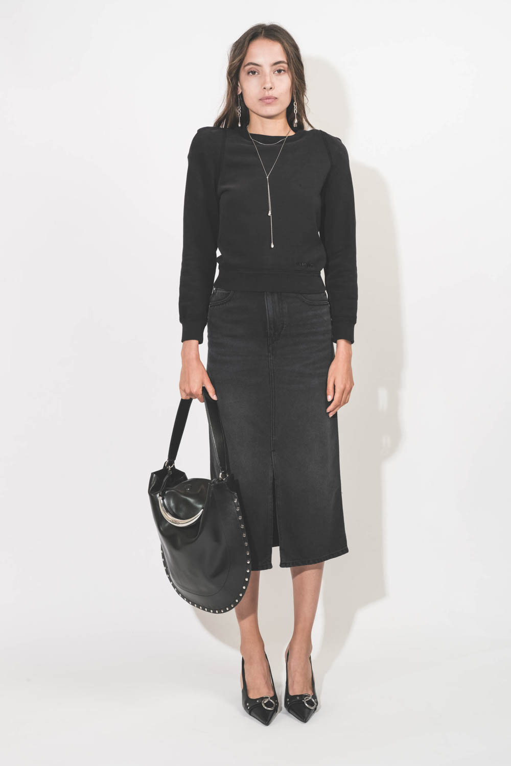 Sac bandoulière courte porté épaule ou porté main en cuir lisse noir poignée bijou en métal argenté Oskan Hobo Isabel Marant. Porté de face.
