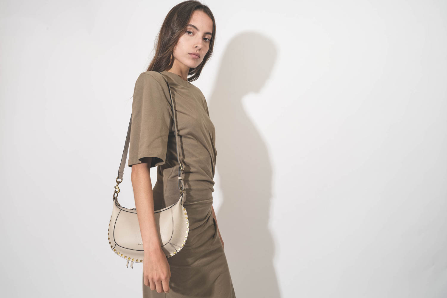 Mini sac en cuir écru clouté finition métal doré Oskan Moon Isabel Marant. Porté de face. 