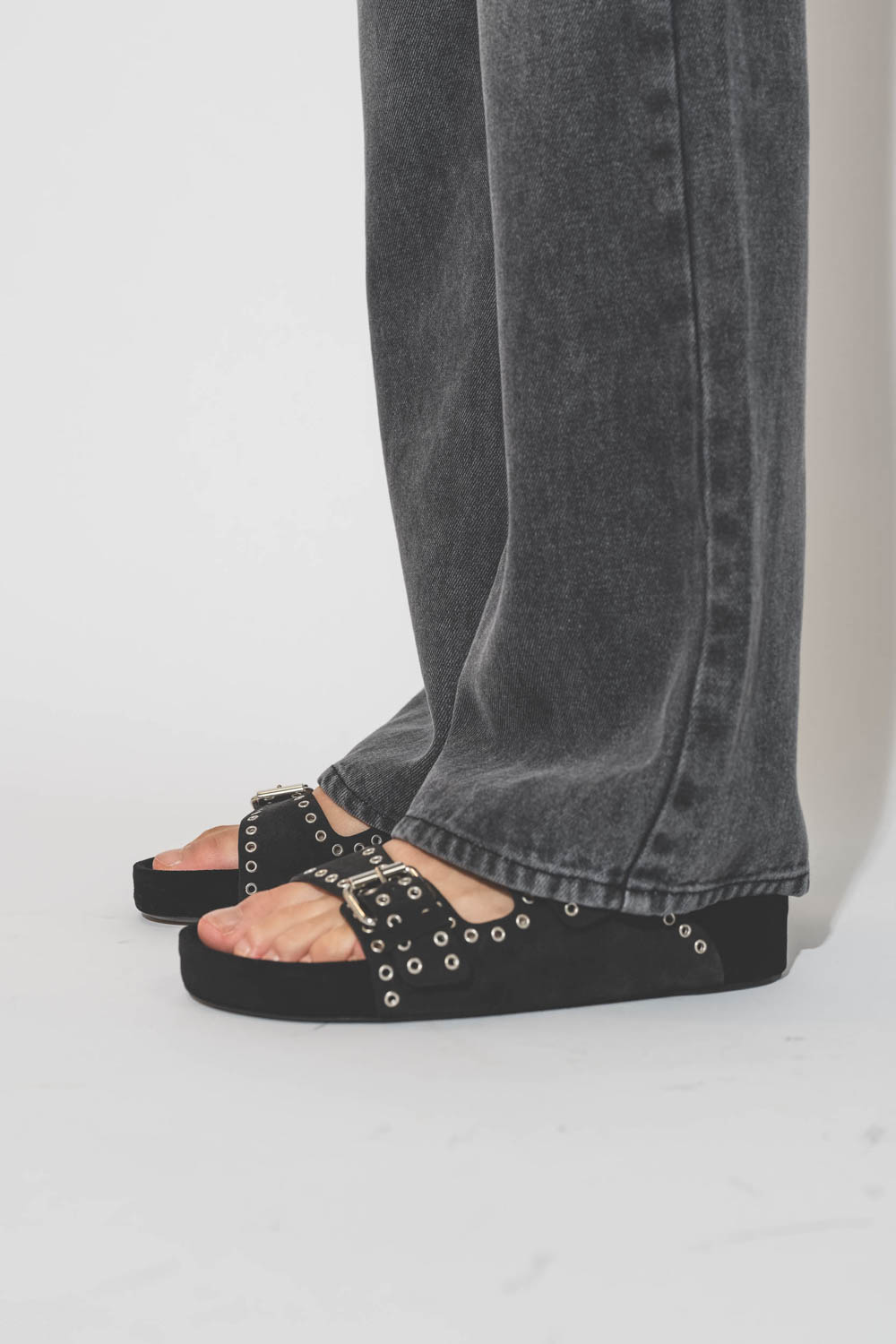 Sandales ouvertes en cuir suédé noir délavé et clouté Lennyo Isabel Marant. Porté avec un jean gris fluide.
