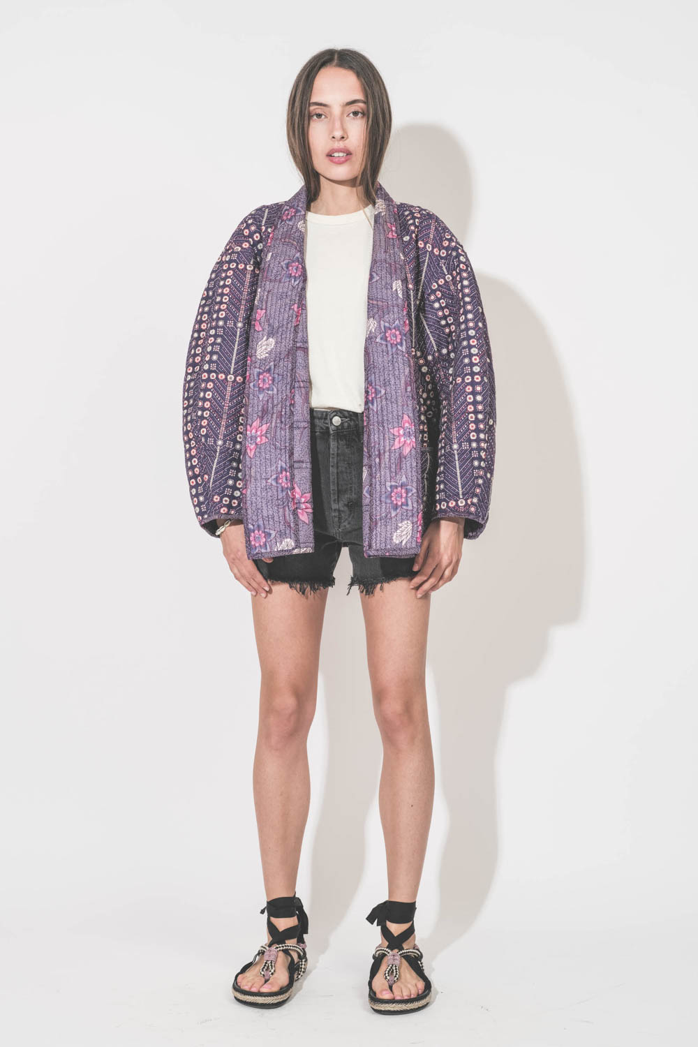 Sandales plates cordes tressées multicolores et rubans noirs Gypsa Isabel Marant. Portées avec une veste Chancel Isabel Marant, un tee-shirt boxy crew écru The Great et un short en jean noir Mikuta.