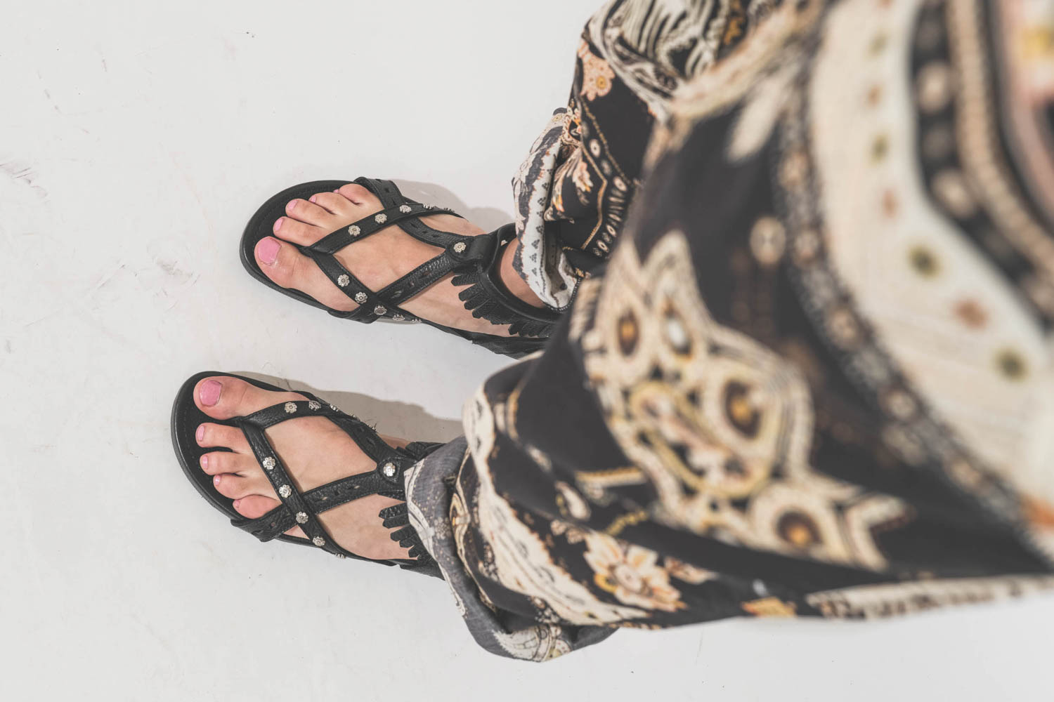 Sandales en cuir noir clouté bride à franges autour de la cheville Silya Isabel Marant. Porté avec un pantalon en voile de coton imprimé Fedora Marant Etoile.