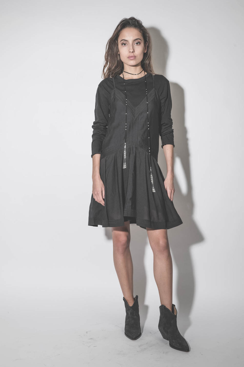Sautoir écharpe en cuir suédé et métal argenté Kachina Isabel Marant. Porté sur une robe noire.