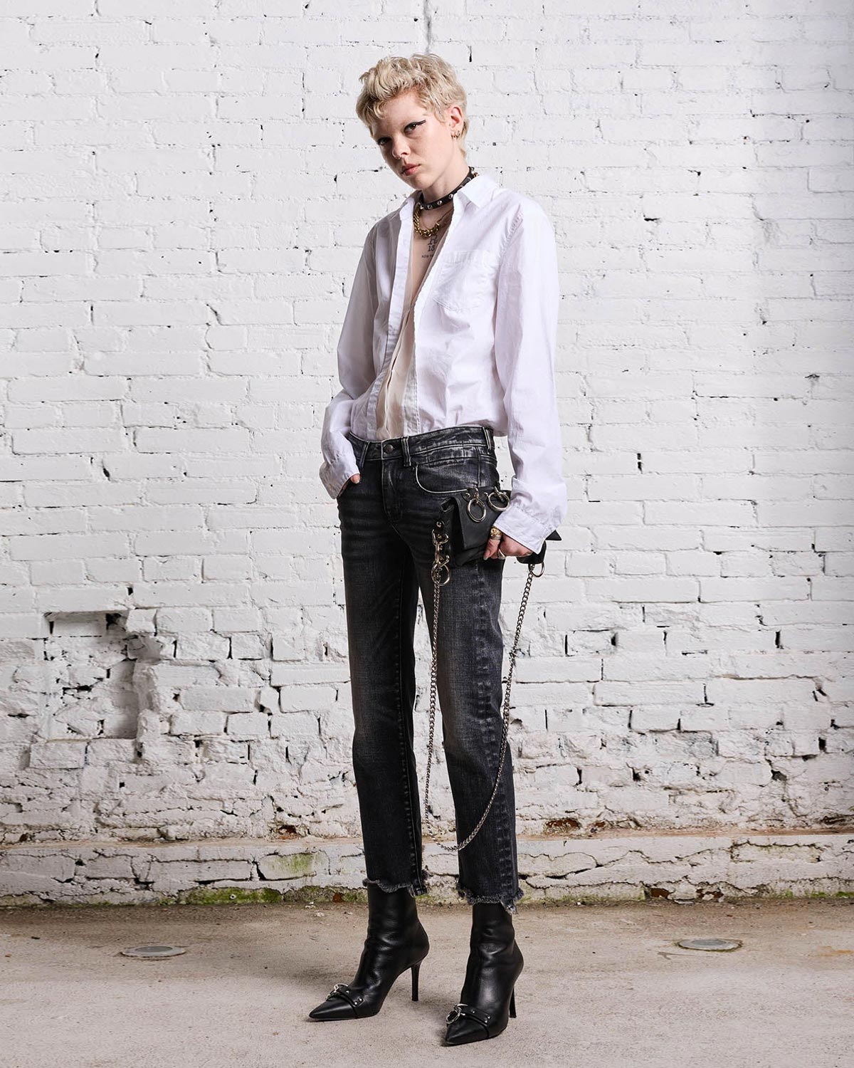 Chemise blanche manches longues en coton blanc empiècement transparent devant à la boutonnière R13. Porté avec un jeans boy straight noir.