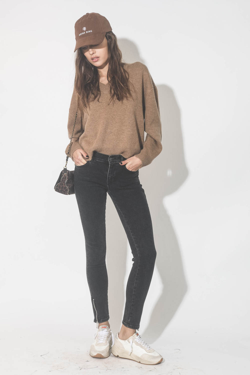 Jeans skinny noir avec zips Jax Anine Bing. Porté avec un pull en cachemire camel.