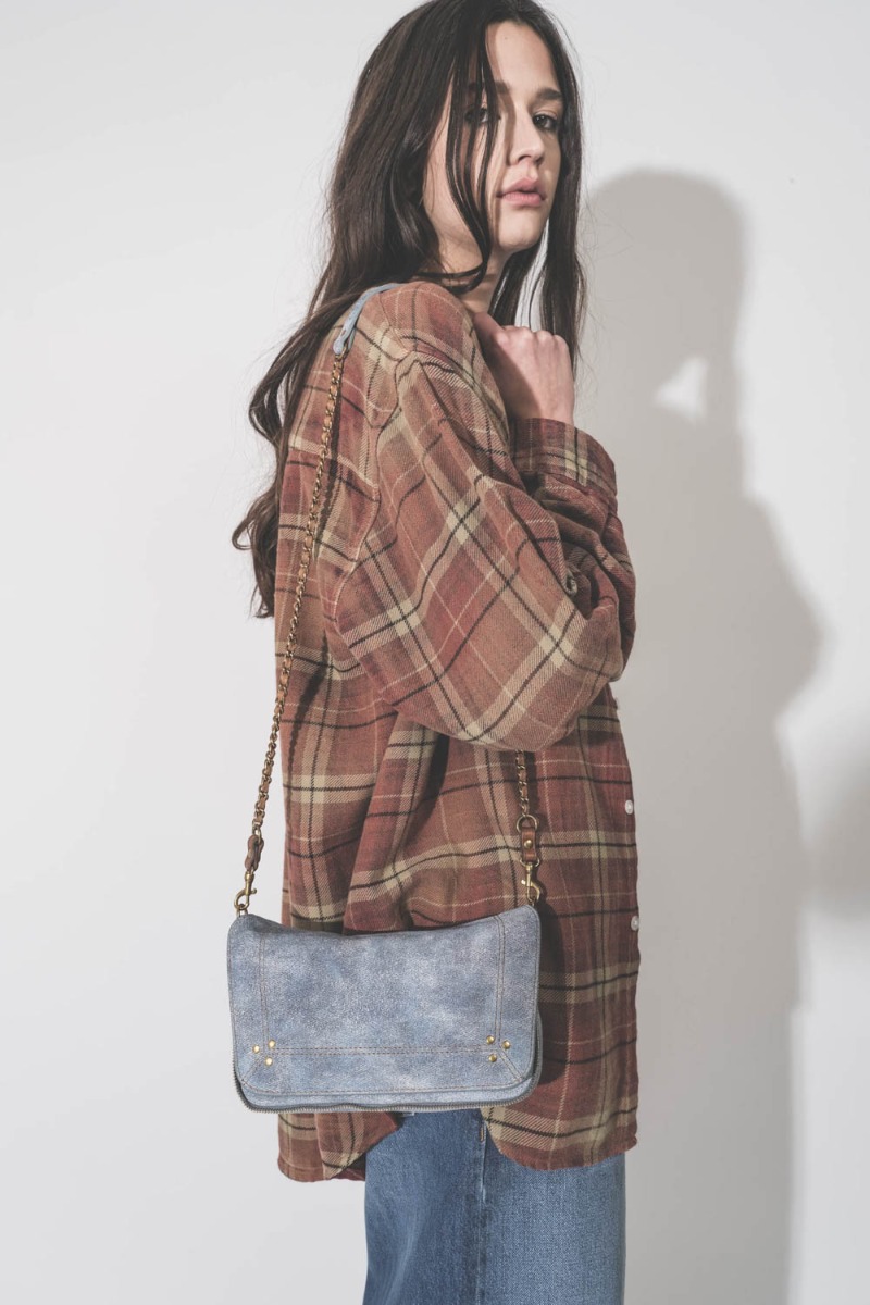 Sac Bobi S J&eacute;r&ocirc;me Dreyfuss en cuir su&eacute;d&eacute; effet jean d&eacute;lav&eacute;, port&eacute; de profil &agrave; l'&eacute;paule.