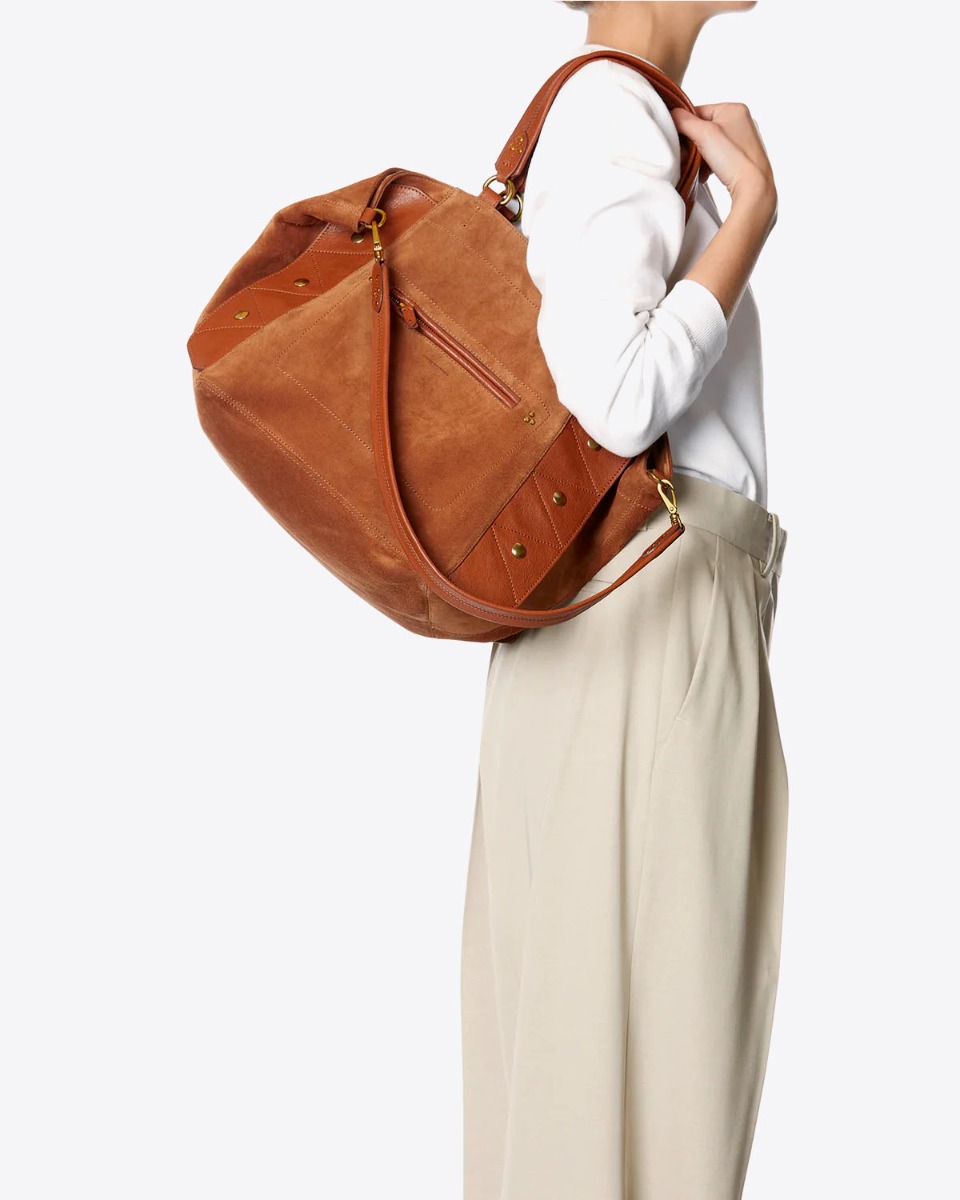 Sac cabas Roger Jérôme Dreyfuss en cuir suédé caramel porté à l'épaule.
