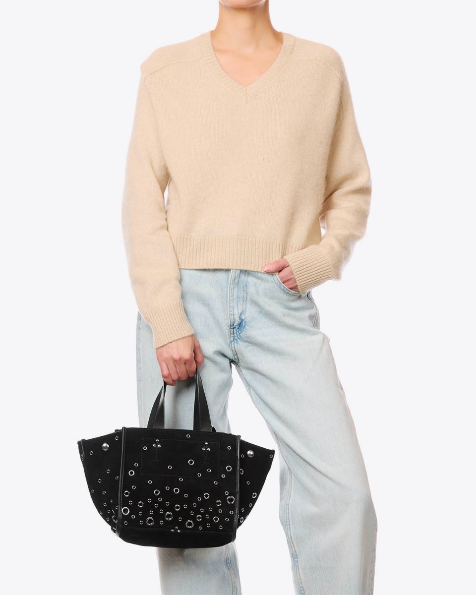 Sac cabas L&eacute;on S J&eacute;r&ocirc;me Dreyfuss en cuir su&eacute;d&eacute; noir avec des incrustations d'oeillets en m&eacute;tal argent&eacute;, port&eacute; de face &agrave; la main.